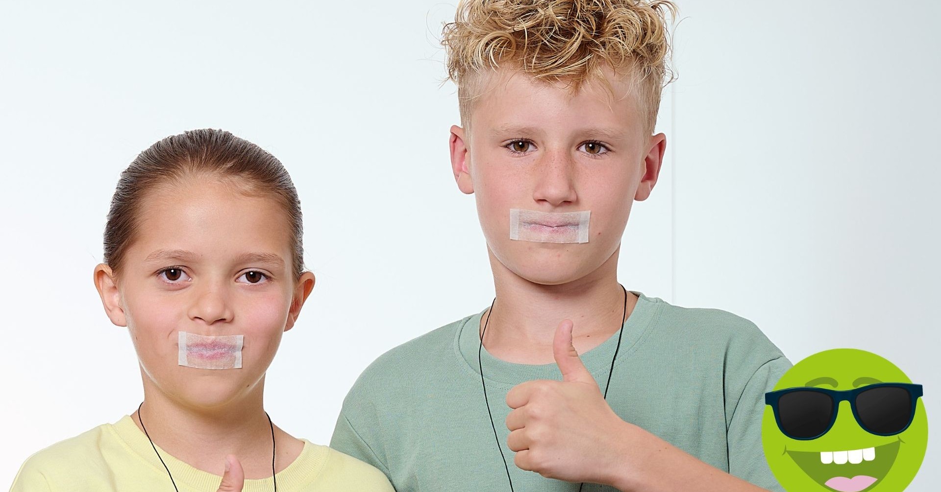 2 Kinder lächeln mit Daumen hoch und getaptend Mund in die Kamera